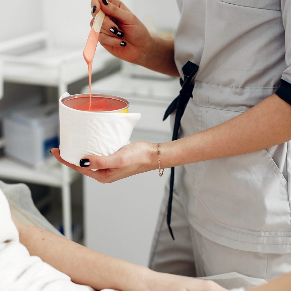 Beautiful girl doing hair removal. Woman in beauty salon